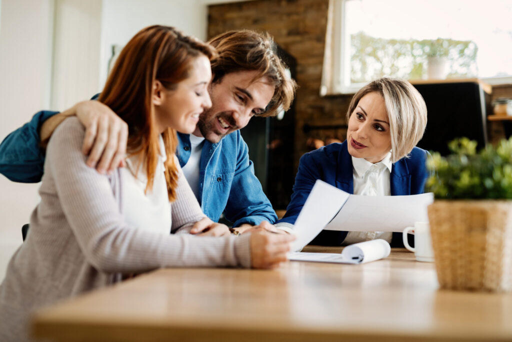 Happy insurance agent having a meeting with young couple.