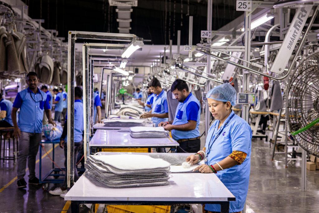 pexels-photo-31091541-31091541 Blue-collar staff in a textile factory focusing on garment production and quality control.